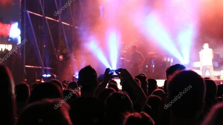 Audience watching a live band on stage with colourful lights