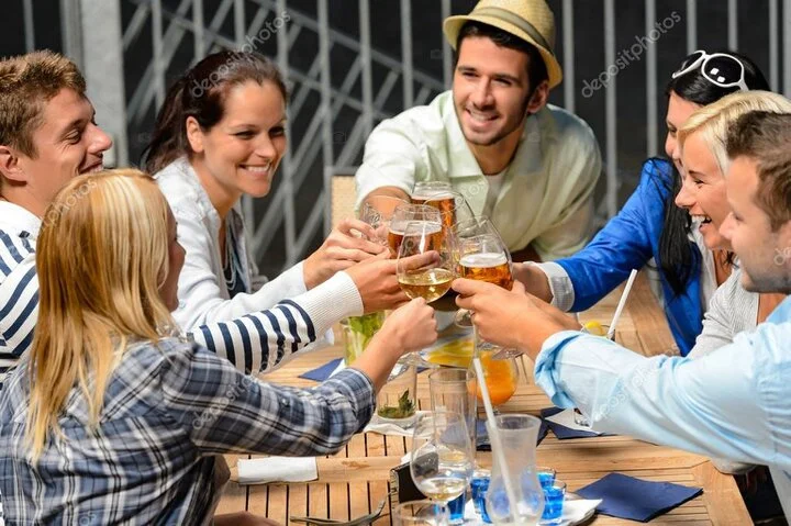 Friends raising drinks together at the club bar